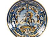 une assiette bleue et dorée sur laquelle figure l'image d'un homme à cheval
