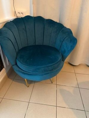 une chaise bleue qui se trouve dans un coin de la pièce