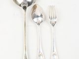 a spoon, fork, and spoon rest on a table