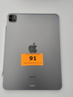 un iPad d'Apple orné d'un autocollant, posé à côté d'un stylo