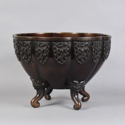 un bol ancien en bronze sur pied, sur fond blanc