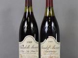 two bottles of wine sitting on top of a table next to each other