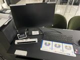 un bureau sur lequel se trouvent un écran d'ordinateur, un clavier, une souris et d'autres objets