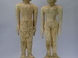 une paire de statues en bois sculpté représentant un homme et une femme debout l'un à côté de l'autre