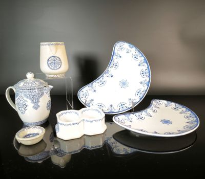 several pieces of blue and white china sitting on a black table