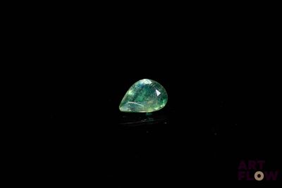 gros plan d'un diamant vert sur une surface noire