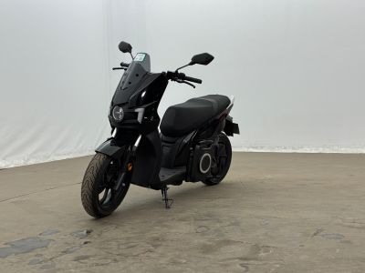 a black motor scooter that is parked in a room