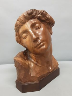 a close up of a sculpture of a man ' s head on a wooden base