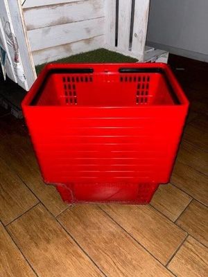 a red plastic crate sitting on the floor next to a door