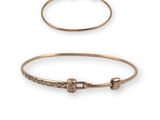 a pair of gold bangles with small stones on them
