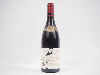 a bottle of red wine sitting on top of a white table