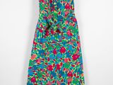 a colorful dress hanging on a hanger against a white wall