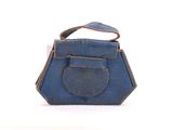 un sac à main bleu posé sur une surface blanche