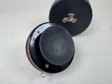 a small black box with a black lid on a white table