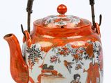 une théière orange et blanche avec une anse et une femme dans un jardin