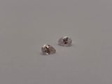 a pair of two pear shaped diamonds on a white surface
