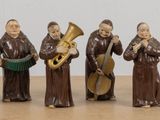 des figurines représentant un groupe de personnes avec des instruments de musique posées sur une table