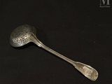 a silver spoon with a metal handle on a black surface