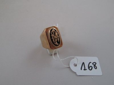 a gold ring with a black and white seal on it