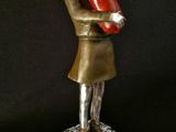 statue of a woman holding a red object on a black surface