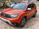 an orange nissan suv parked in a parking lot next to other cars