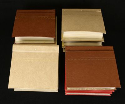 four books are lined up on top of each other on a black surface