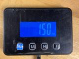 a digital clock on a table with a charger