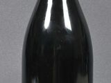a black bottle with a label on it sitting on a table