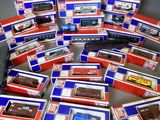 Plusieurs boîtes de trains miniatures sont empilées les unes sur les autres