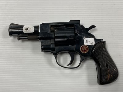 un gros plan d'un revolver posé sur une table, avec une étiquette dessus