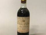 une bouteille de vin posée sur une table blanche