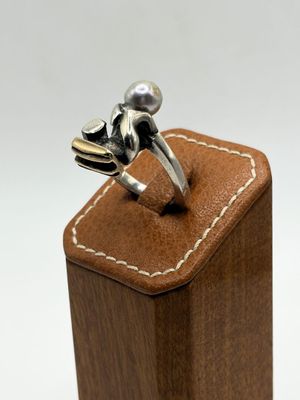 sterling silver frog ring on leather box on white background