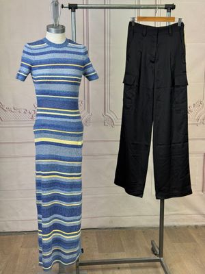 blue and yellow striped dress on a mannequin stand next to a pair of black pants