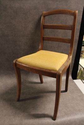 une chaise en bois avec une assise jaune sur fond gris