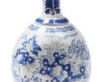 a blue and white vase sitting on a white surface