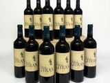 six bouteilles de vin sont alignées sur une surface blanche