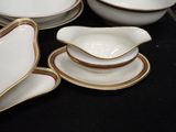 a lot of white and gold plates and bowls on the table