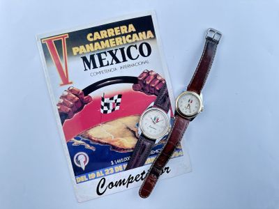 une montre posée sur une table à côté d'un livre