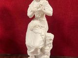 une statue blanche représentant une femme avec un chien, posée sur une table