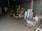 many pieces of furniture in a warehouse with pallets of wood