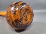 a picture of a pipe with a wooden handle on a gray background