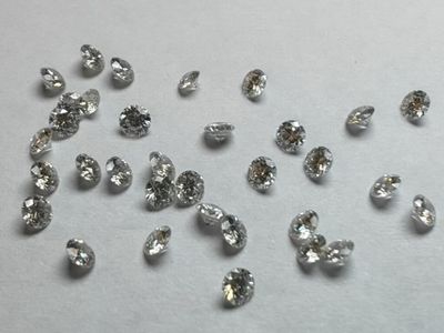 des diamants sont dispersés sur une surface blanche, sur fond blanc