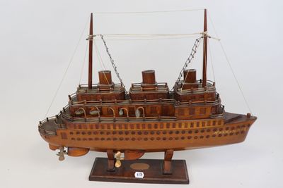 une maquette en bois de bateau posée sur un socle