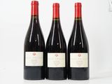 trois bouteilles de vin rouge posées sur une table blanche