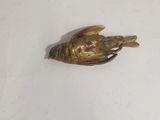 a gold bird that is sitting on top of a white table