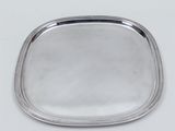 a silver tray with beaded edge on a white surface