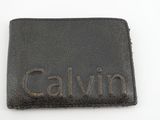 portefeuille en cuir noir sur lequel est gravé le nom « Calvin »