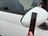 a person holding a ruler in front of a car