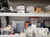 many boxes and containers on a shelf in a room