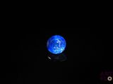 Dans l'obscurité, la boule bleue s'illumine d'une lumière bleue